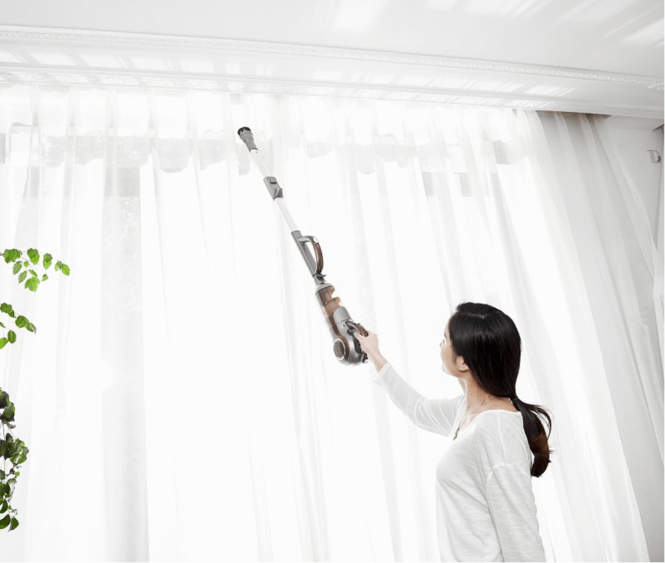 Lady vacuuming her sheer curtains